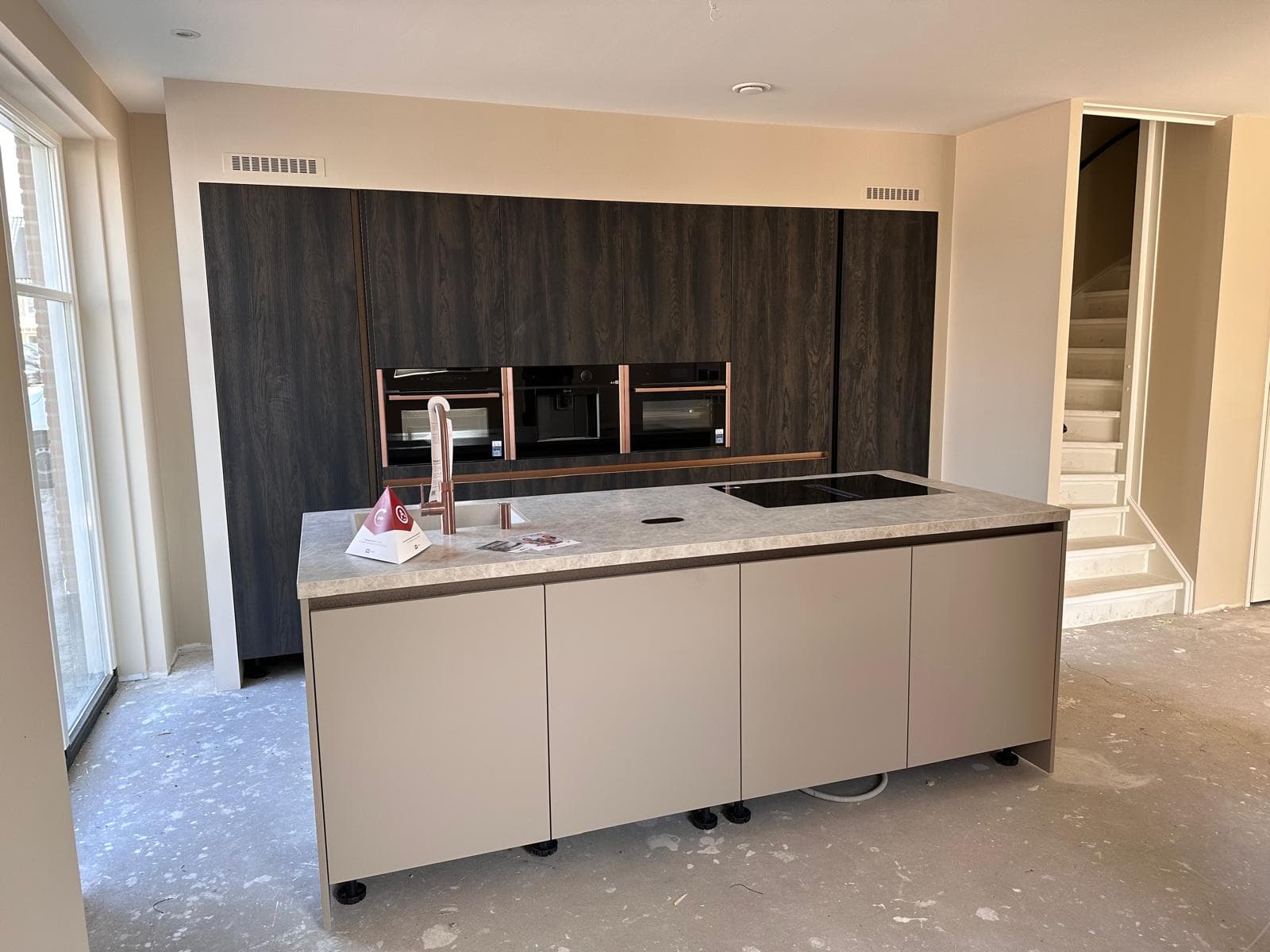 Donkere houtlook keuken met open verbinding naar het trapgat